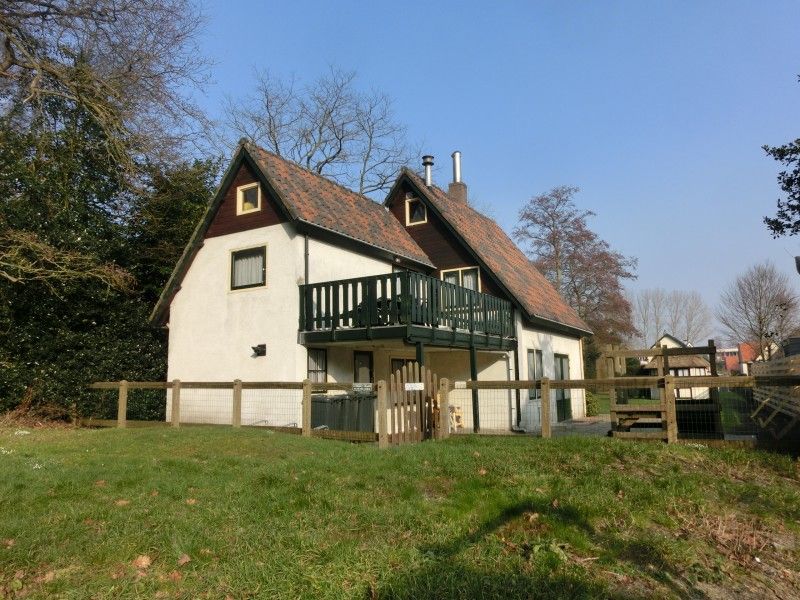 Achterzijde van vakantiehuis Maria in Schoorl met balkon en omheinde tuin