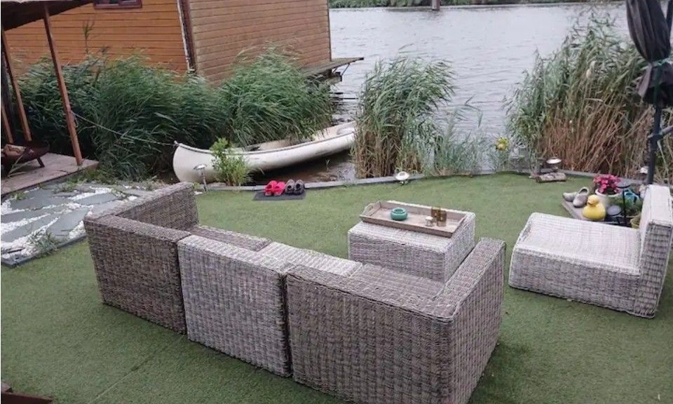 Sfeervolle avondverlichting bij Wagen Cosy, Spaarndam, weerspiegelt in de vijver voor een magische glamping ervaring aan de Noordzeekust.