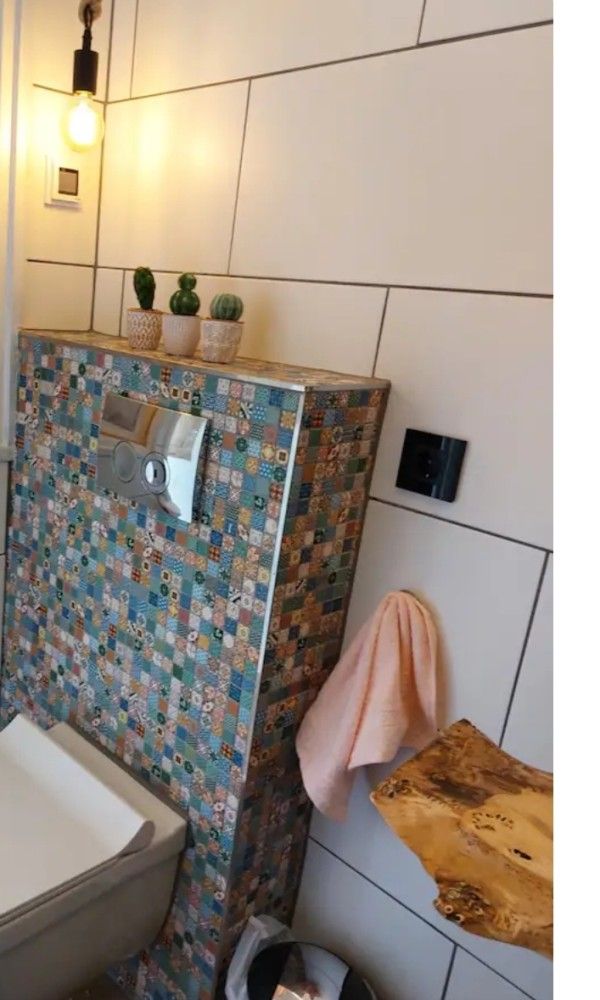 Moderne badkamer in Wagen Cosy, Spaarndam, met kleurrijke tegels en houten details, perfect voor een luxe verblijf aan de Noordzeekust.