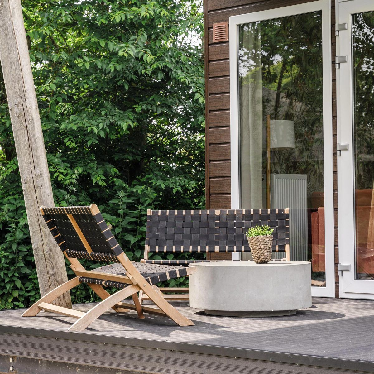 Cozy terrace of Beach House sleeps 6, vacation home in Julianadorp, North Sea coast, North Holland, with modern seating area and green surroundings.