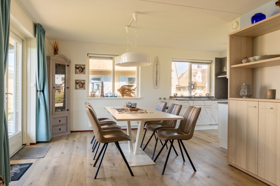 Moderne eetkamer in Villa Luxe 6, een vakantiehuis in Julianadorp aan de Noordzeekust, Noord-Holland, met veel natuurlijk licht.