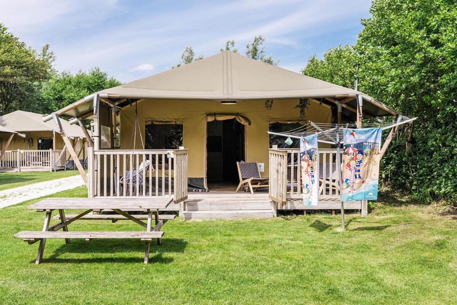 Strandtent 8 personen in Julianadorp, Noordzeekust. Luxe safaritent met veranda en groene omgeving in Noord-Holland.