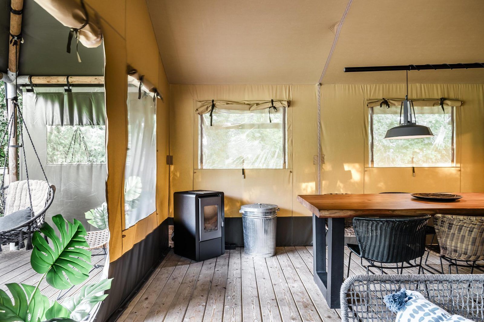 Binnenruimte van Strandtent 8 personen in Julianadorp, Noordzeekust. Gezellige glamping lodge met houten vloer en lichtinval door ramen.