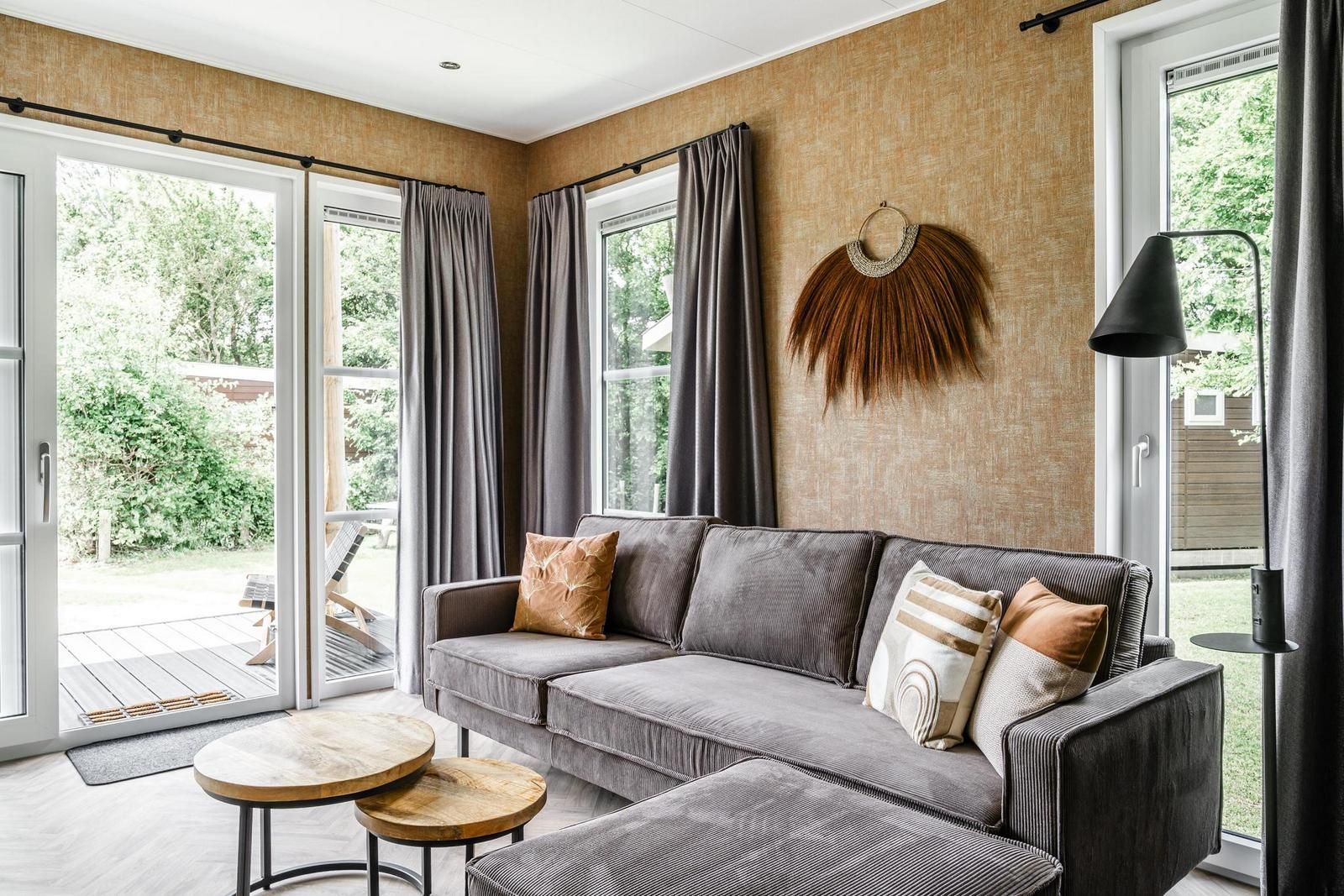 Gemuetliches Wohnzimmer der Strandhuisje 4 Personen in Julianadorp, Nordseekueste. Gemuetliche Sitzecke mit Blick auf die gruene Umgebung.