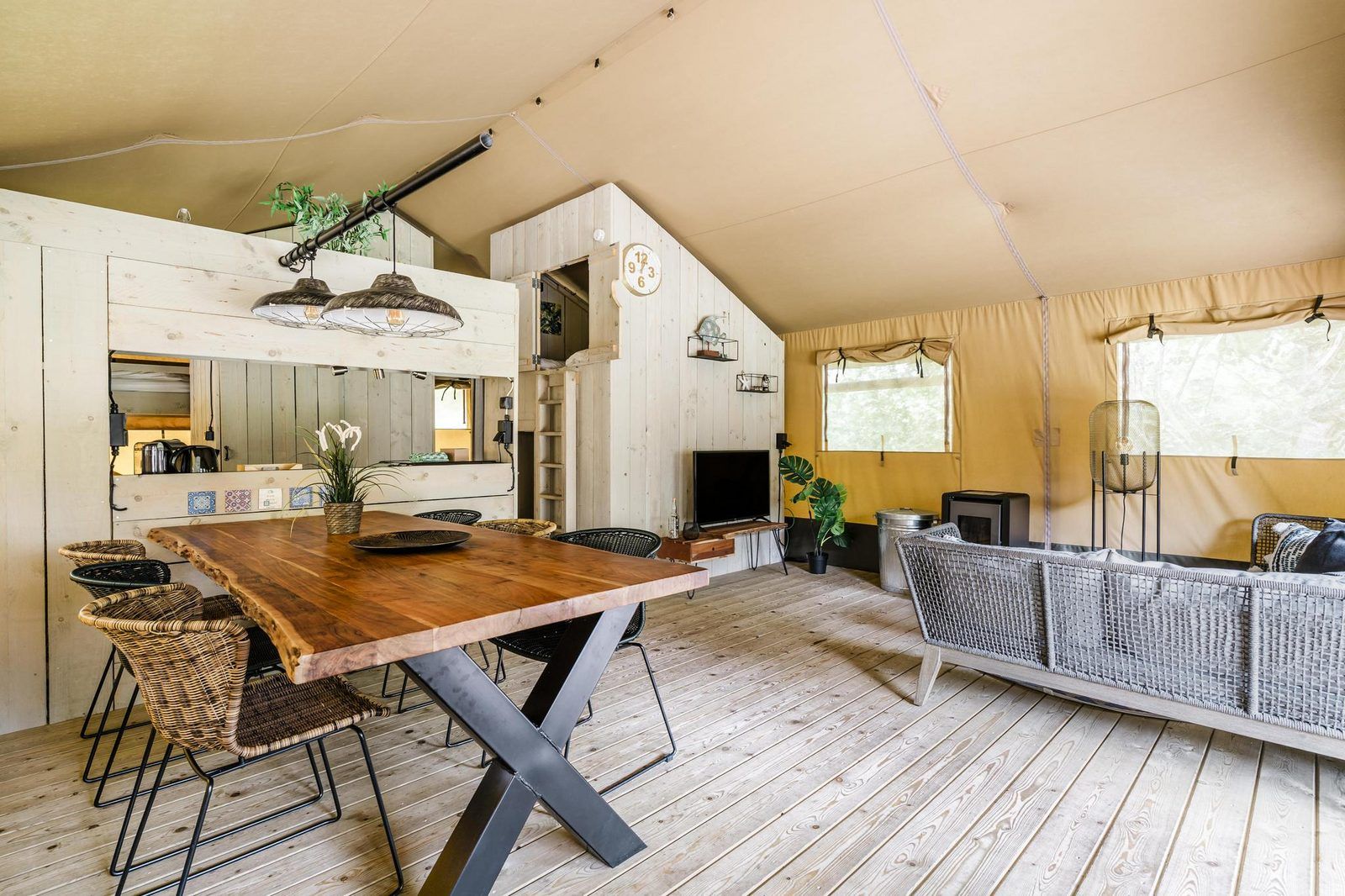 Innenansicht des Strandzeltes fuer 6 Personen in Julianadorp, Nordholland. Gemuetliche Glamping-Lodge mit Holzinterieur und komfortabler Sitzecke.