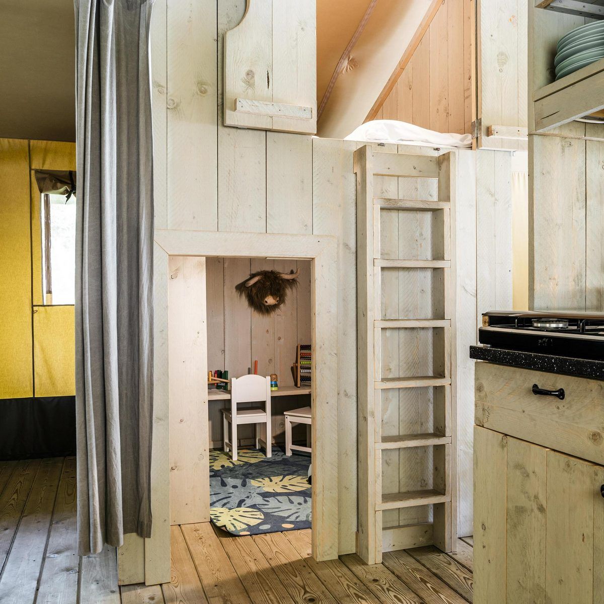 Gemuetliches Interieur des Strandzeltes fuer 6 Personen in Julianadorp, Nordseekueste, Nordholland. Perfekte Glamping Lodge fuer Familien.