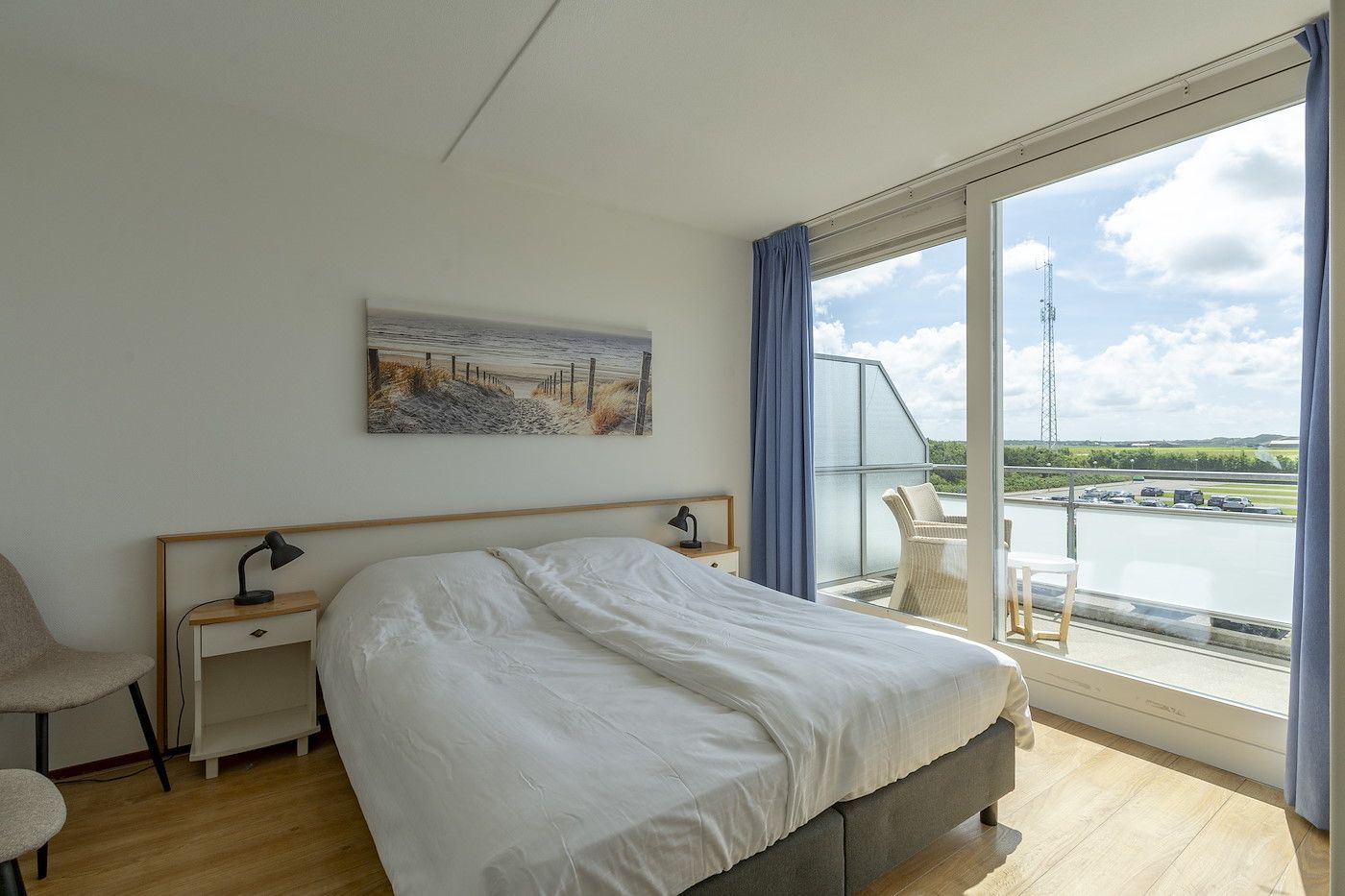 Schlafzimmer im Ferienhaus Duinerei B202 Groote Keeten, Callantsoog, mit Blick auf Balkon und Natur.