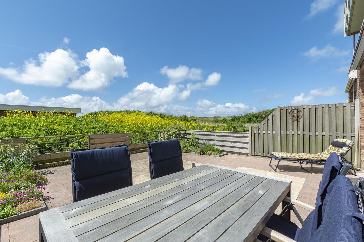 Cozy terrace with view at Duinerei C002 Groote Keeten vacation home in Callantsoog, North Sea coast, North Holland.