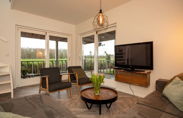 Moderne woonkamer van Vakantiehuisje in Callantsoog met uitzicht op de Noordzeekust, Noord-Holland.