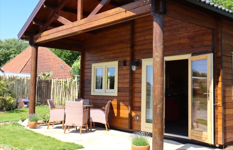 Geniessen Sie die sonnige Veranda des Ferienhauses in Callantsoog, Nordseekueste, Nordholland mit bequemen Sitzgelegenheiten.