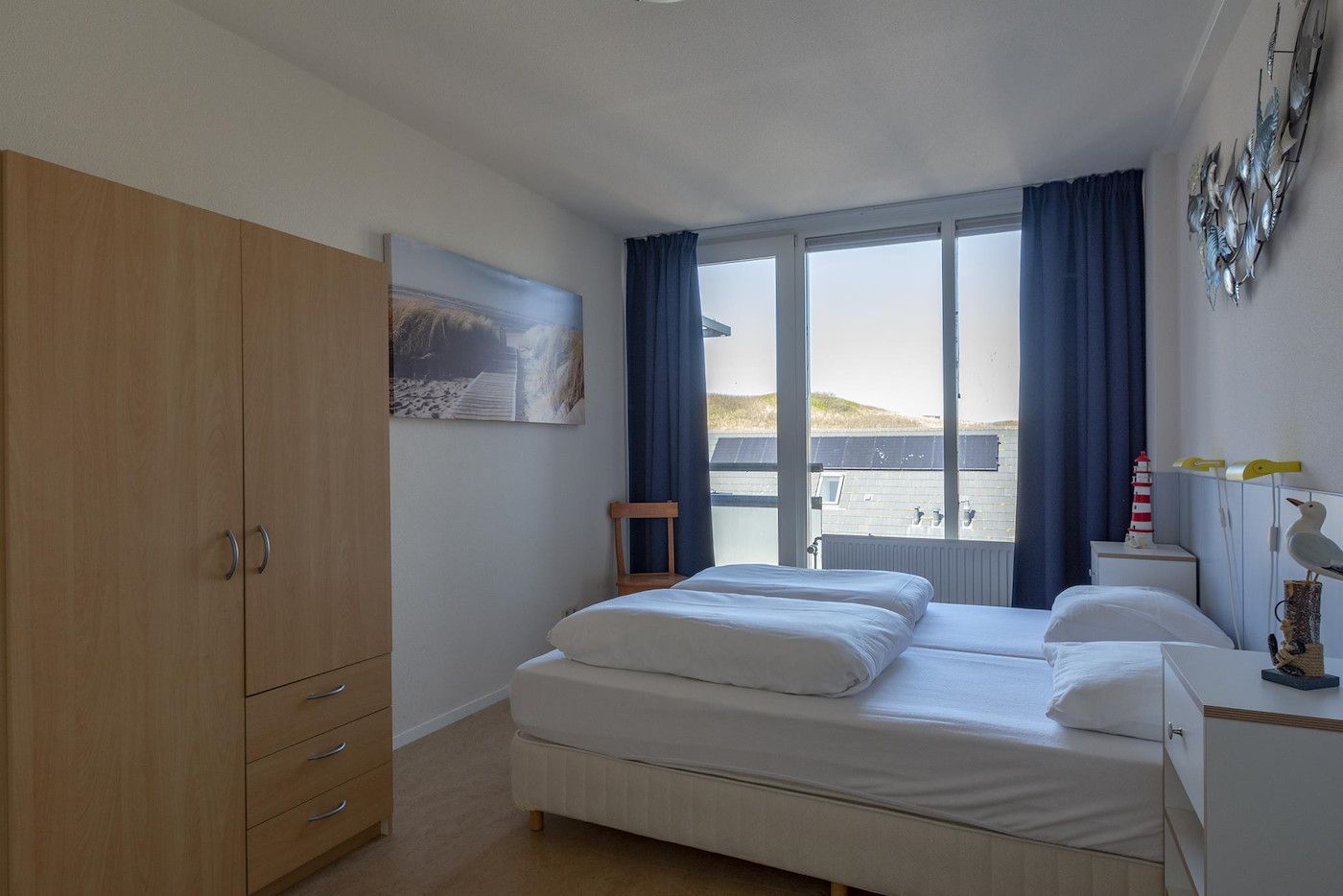 Comfortable bedroom in Dorpsplein 23E Callantsoog vacation home, overlooking dunes, North Holland.
