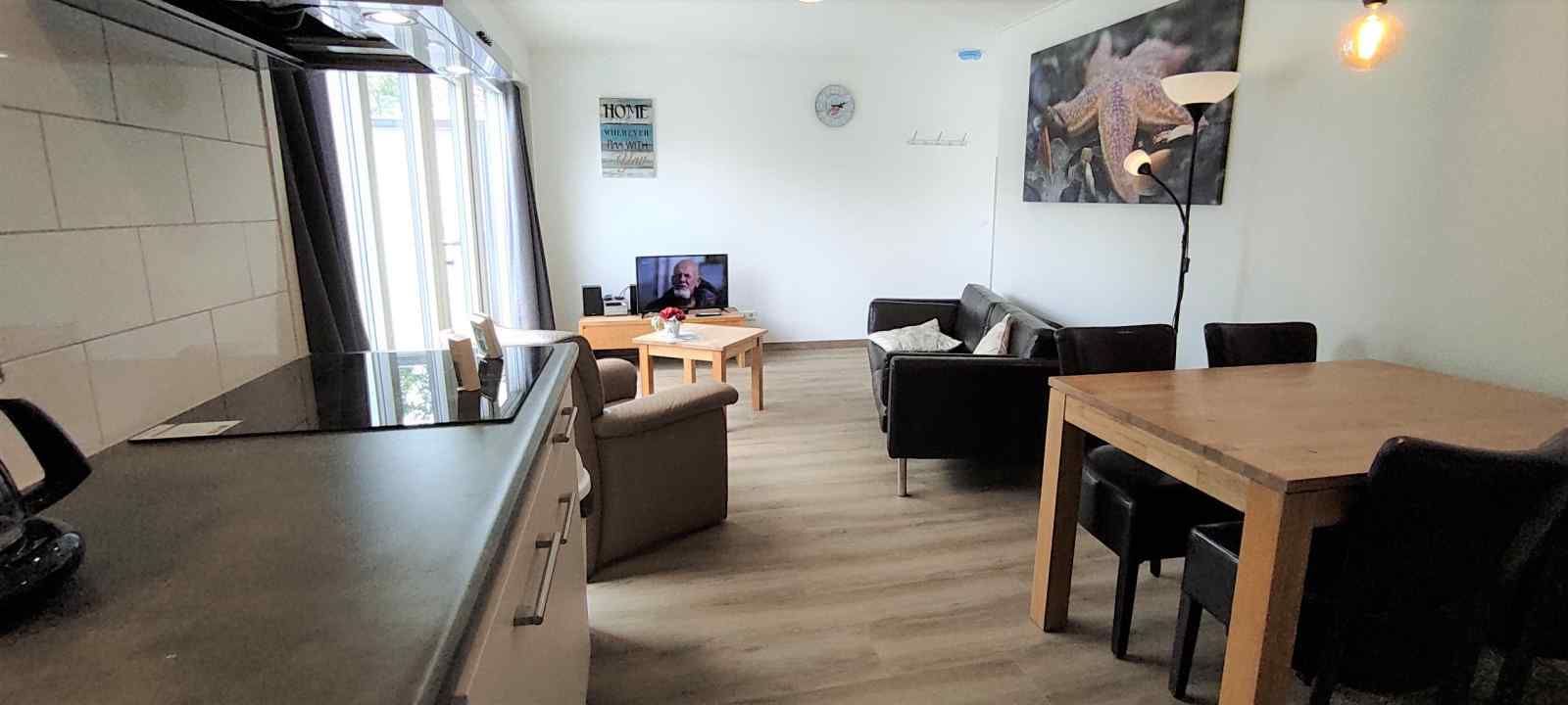 Stilvolles Badezimmer des NH213 Ferienhauses in Callantsoog, Nordholland, mit Waschbecken und beleuchtetem Spiegel.