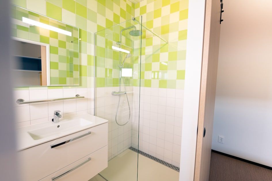 Badezimmer in Royal Dune 4, Callantsoog, mit frischen gruenen Fliesen und geraeumiger Dusche.