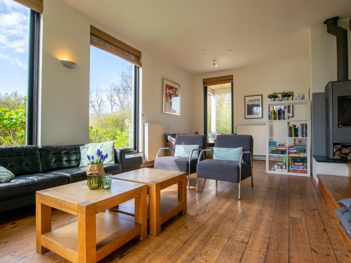 Gezellige woonkamer van Landhuis Duinzicht in Callantsoog, Noordzeekust, Noord-Holland, met uitzicht op de natuur en comfortabele zithoek.