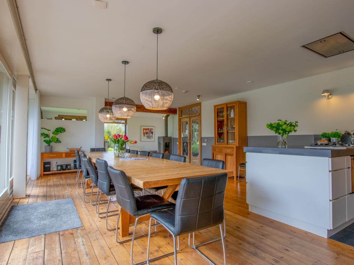 Gezellige eetkamer in Landhuis Duinzicht, een vakantiehuis in Callantsoog aan de Noordzeekust, Noord-Holland, met houten vloeren en moderne inrichting.