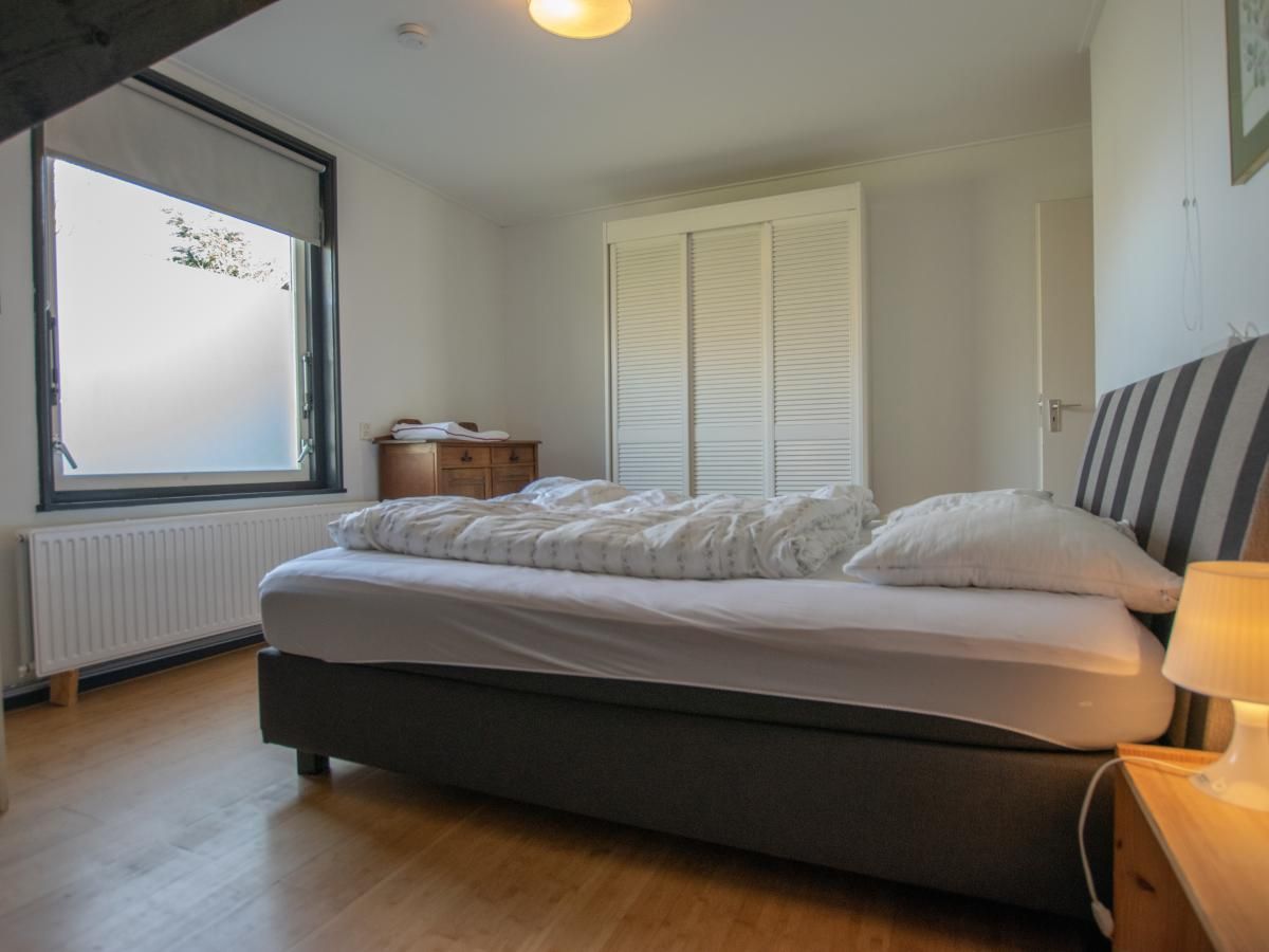 Sfeervolle slaapkamer in Landhuis Duinzicht, vakantiehuis in Callantsoog, Noord-Holland, met comfortabel bed en rustgevend interieur.