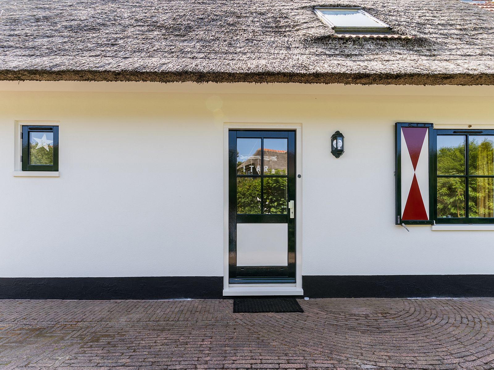 Charmanter Eingang zu einem freistehenden Haus in Callantsoog, an der Nordseekste in Nordholland gelegen, mit Reetdach und lndlicher Atmosphre.