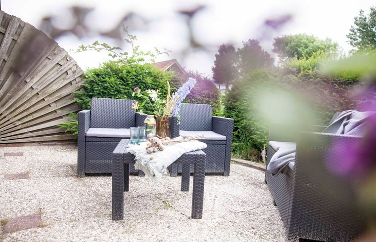 Sonnige Terrasse am Ferienhaus in Callantsoog, Nordseekueste, Nordholland, mit bequemen Sitzgelegenheiten.