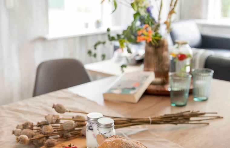 Esstisch mit Dekoration im Ferienhaus in Callantsoog, Nordseekueste, Nordholland, bereit fuer eine Mahlzeit.