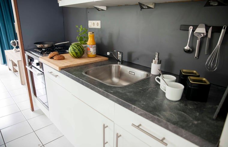 Kompakte Kueche im Ferienhaus in Callantsoog, Nordseekueste, Nordholland, mit frischen Zutaten.