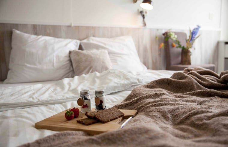 Schlafzimmer im Ferienhaus in Callantsoog, Nordseekueste, Nordholland, mit Fruehstueck im Bett.