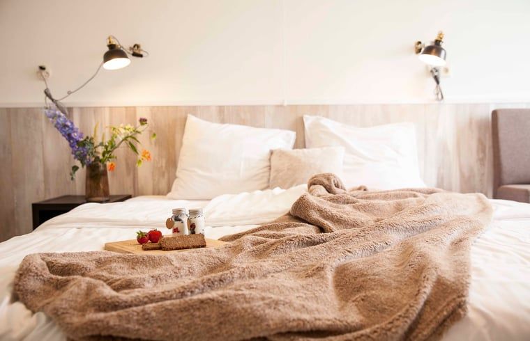 Gemuetliches Schlafzimmer im Ferienhaus in Callantsoog, Nordseekueste, Nordholland, mit weichen Decken.