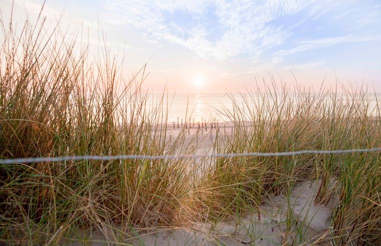 Schoener Sonnenuntergang im Ferienhaus in Callantsoog, Nordseekueste, Nordholland, mit Blick auf das Meer.