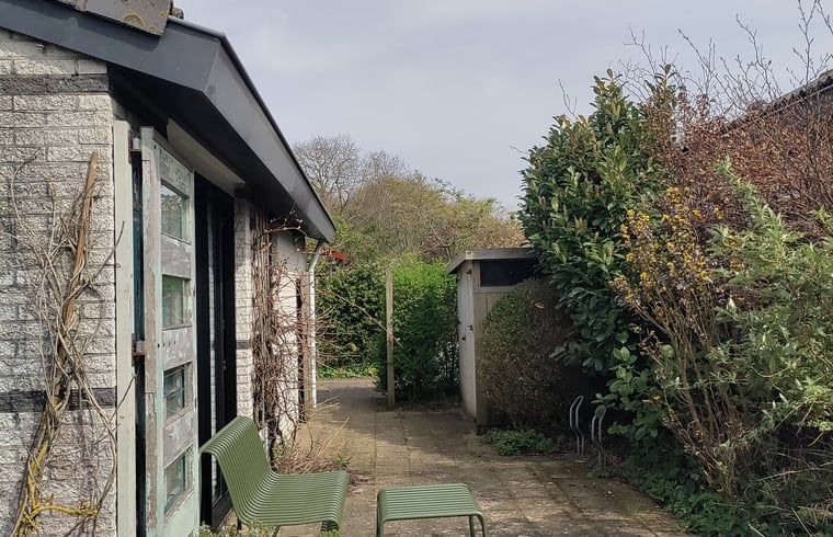 Entspannte Terrasse am Haus in Egmond-Binnen, Ferienhaus an der Nordseekueste, Nordholland, umgeben von gruener Natur.