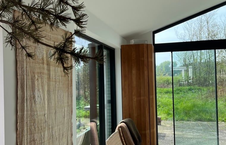 Innenbereich des Ferienhauses in Egmond-Binnen mit Blick auf die gruene Umgebung, Ferienhaus an der Nordseekueste in Nordholland.