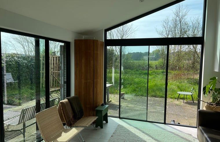 Innenraum des Ferienhauses in Egmond-Binnen mit Blick auf die gruene Natur, an der Nordseekueste in Nordholland gelegen.