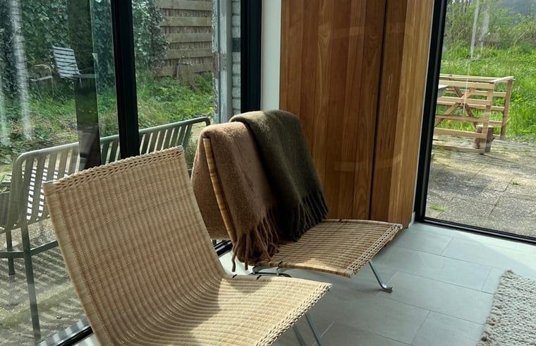 Gemuetlicher Innenbereich des Huisje in Egmond-Binnen, Ferienhaus an der Nordseekueste, Nordholland, mit Blick auf den gruenen Garten.