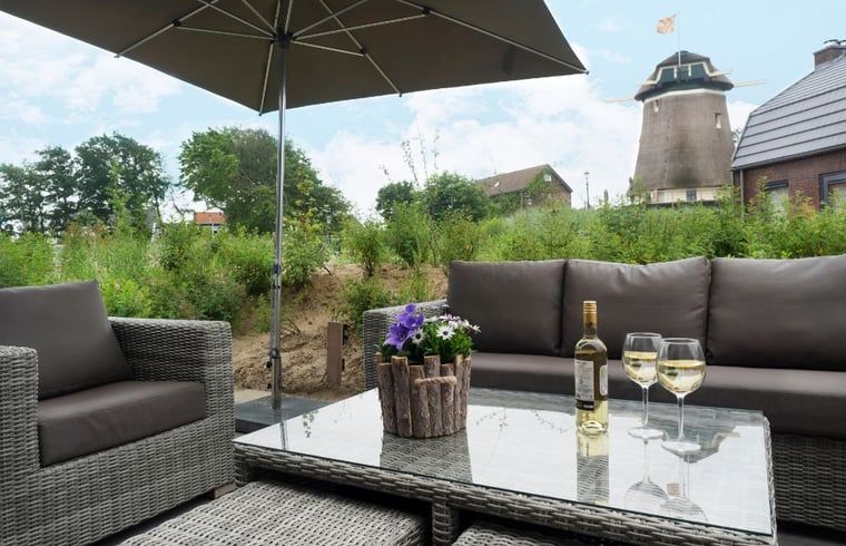 Gezellig terras bij Huisje in Egmond aan den Hoef met uitzicht op een molen, Noordzeekust, Noord-Holland.