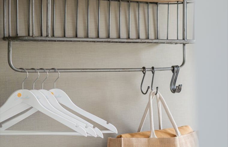 Kapstok met hangers in Huisje in Egmond aan den Hoef, vakantiehuis aan de Noordzeekust, Noord-Holland.