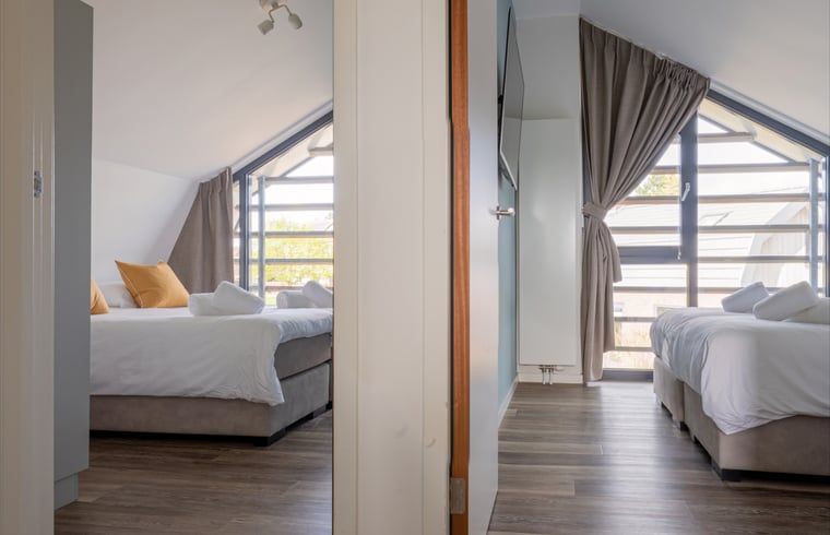 Twee slaapkamers met bedden in Huisje in Egmond aan den Hoef, vakantiehuis aan de Noordzeekust.