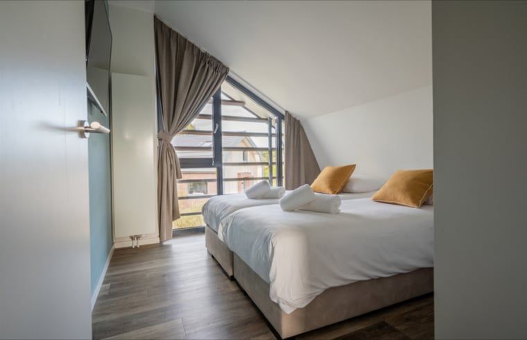 Ruime slaapkamer met uitzicht in Huisje in Egmond aan den Hoef, vakantiehuis aan de Noordzeekust.