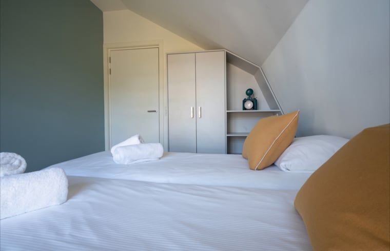 Slaapkamer met tweepersoonsbed in Huisje in Egmond aan den Hoef, vakantiehuis aan de Noordzeekust.