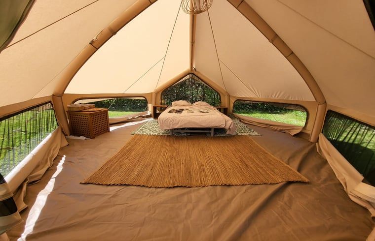 Luxe tentinterieur bij Huisje in Schagerbrug, Schagerbrug, met een gezellig bed en veel natuurlijk licht.