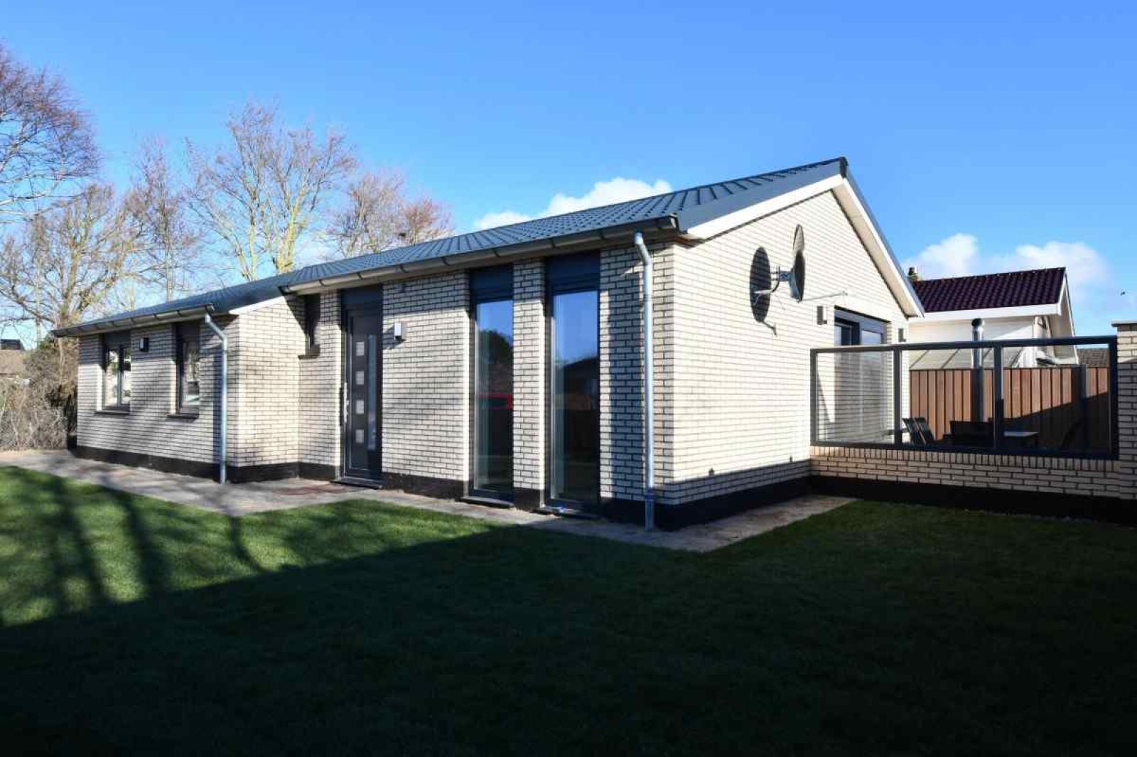 Bright living room in vacation home NH114, Julianadorp aan Zee, North Holland, overlooking garden.