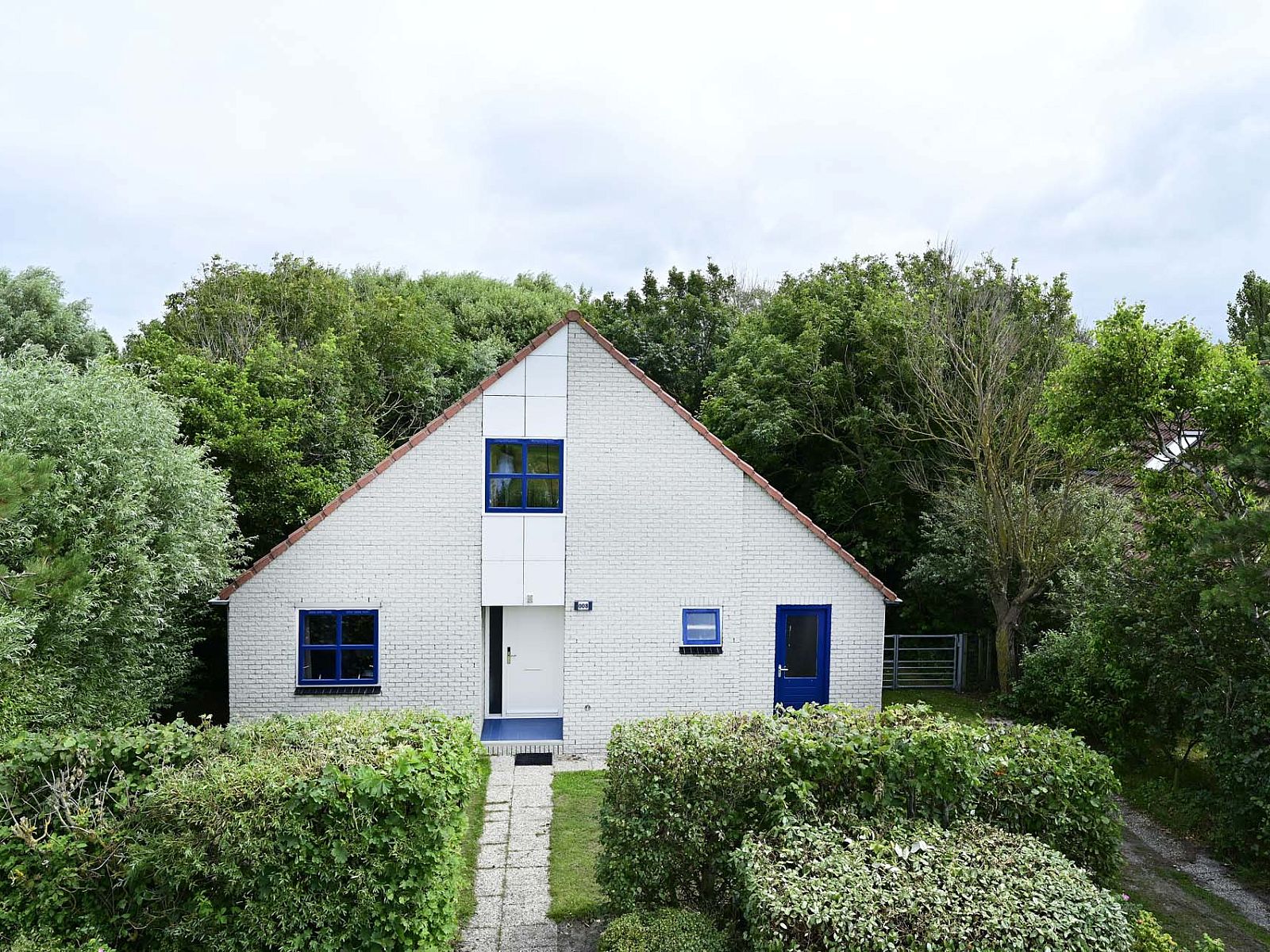 Vooraanzicht van vakantiewoning met omringende natuur in Julianadorp aan Zee.