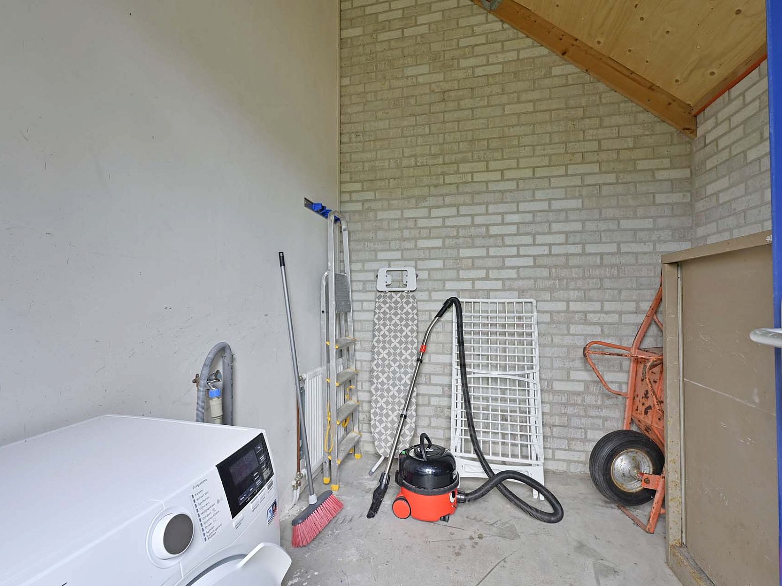 Opbergruimte met wasmachine in vakantiehuis Julianadorp aan Zee.