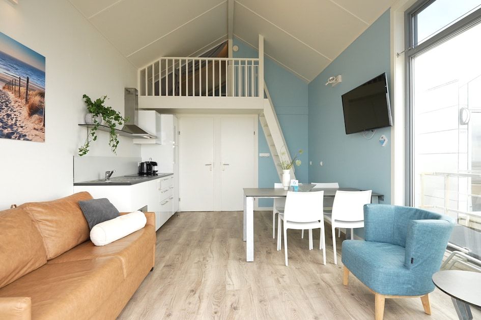 Moderne binnenruimte van Beach House Comfort 4 in Julianadorp aan Zee, Noord-Holland, met comfortabele zithoek en eetruimte.