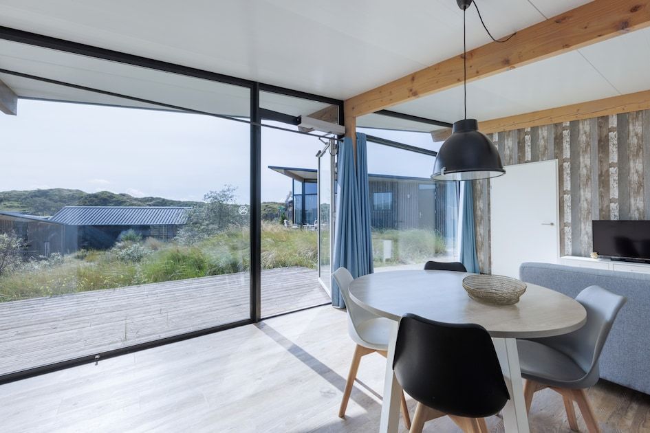 Helles Interieur des Sea House Special Ferienhauses in Overveen, Nordseekueste, mit Blick auf Terrasse und Duenen.