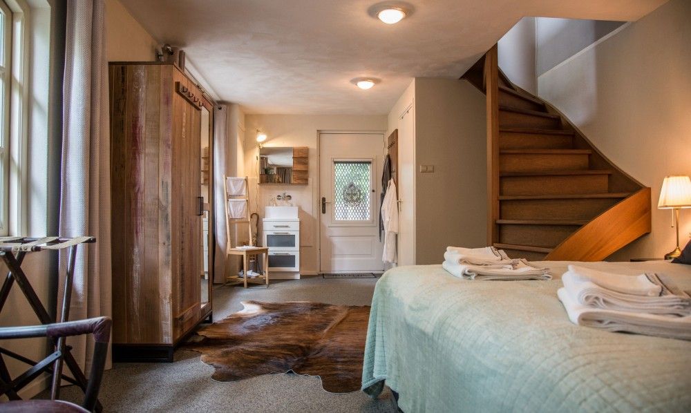 Stijlvolle slaapkamer in Casa Allegria, Bergen, met houten trap en rustieke inrichting voor een ontspannen verblijf.