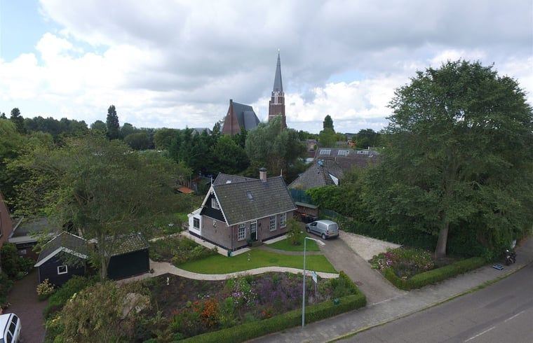 Uitzicht op de kerk en omgeving vanuit Vakantiehuis in Andijk, gelegen in het pittoreske Noord-Holland aan de IJsselmeerkust.