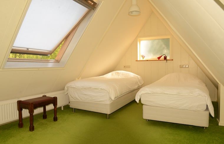 Knusse zolderkamer met twee bedden in Vakantiehuis in Andijk, gelegen in het charmante Noord-Holland aan de IJsselmeerkust.