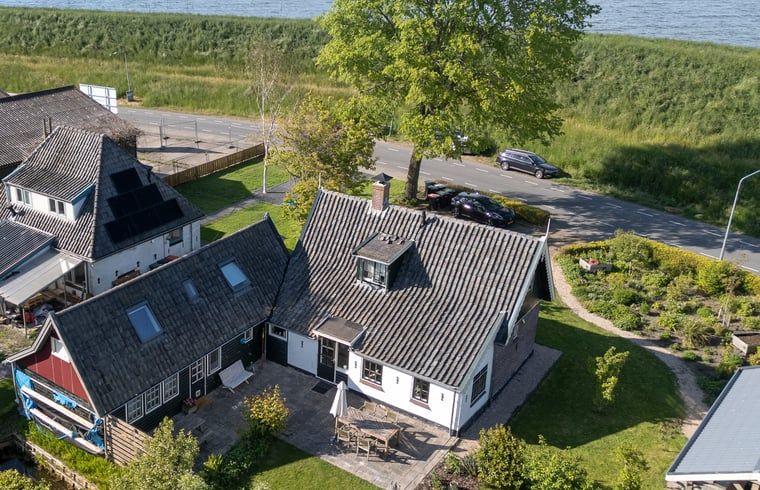 Buitenzijde van Vakantiehuis in Andijk met prachtig uitzicht op het omliggende landschap aan de IJsselmeerkust in Noord-Holland.
