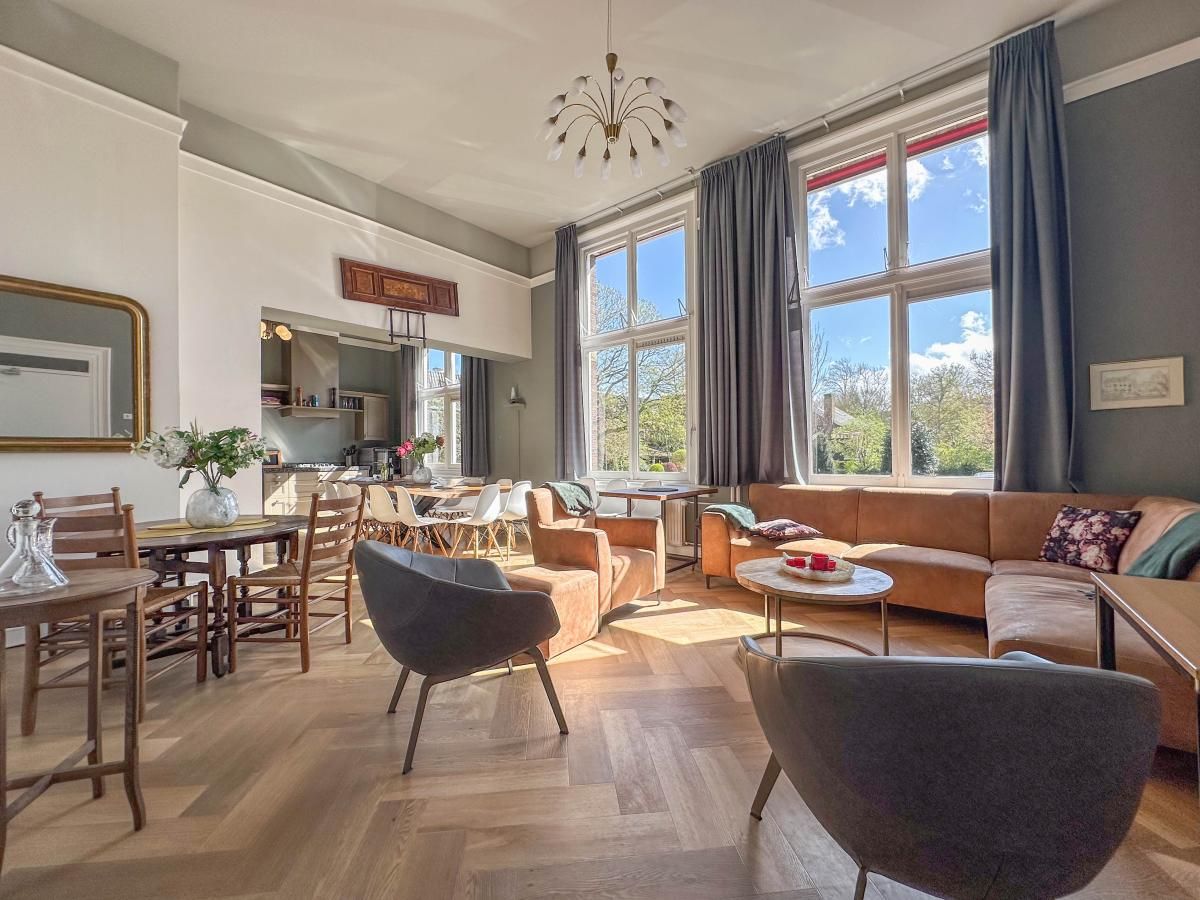 Lichte woonkamer van Groot Weeshuis vakantiehuis in Enkhuizen, Noord-Holland met ruime zithoek en grote ramen met uitzicht op de natuur.