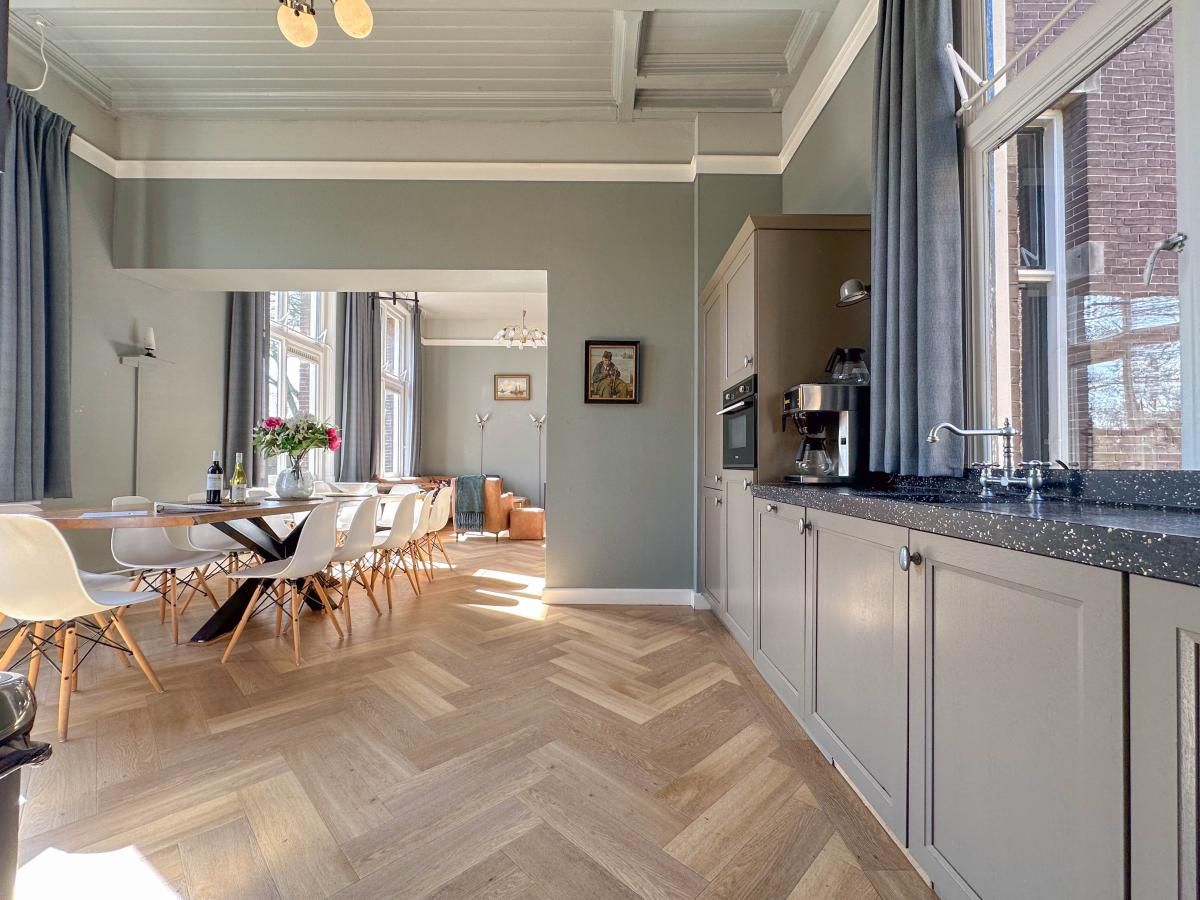 Stijlvolle keuken en eetkamer in vakantiehuis Groot Weeshuis, Enkhuizen, Noord-Holland, met ruime inrichting en veel natuurlijk licht.