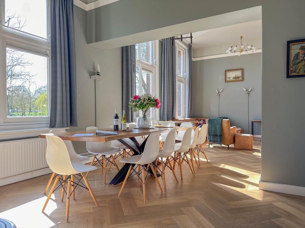 Gezellige eetkamer in vakantiehuis Groot Weeshuis, Enkhuizen, met ruime tafel en veel natuurlijk licht, gelegen aan de IJsselmeerkust, Noord-Holland.