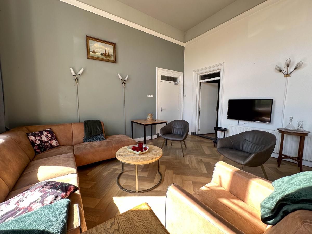 Gezellige woonkamer in vakantiehuis Groot Weeshuis, Enkhuizen. Comfortabele zithoek met moderne inrichting aan de IJsselmeerkust, Noord-Holland.